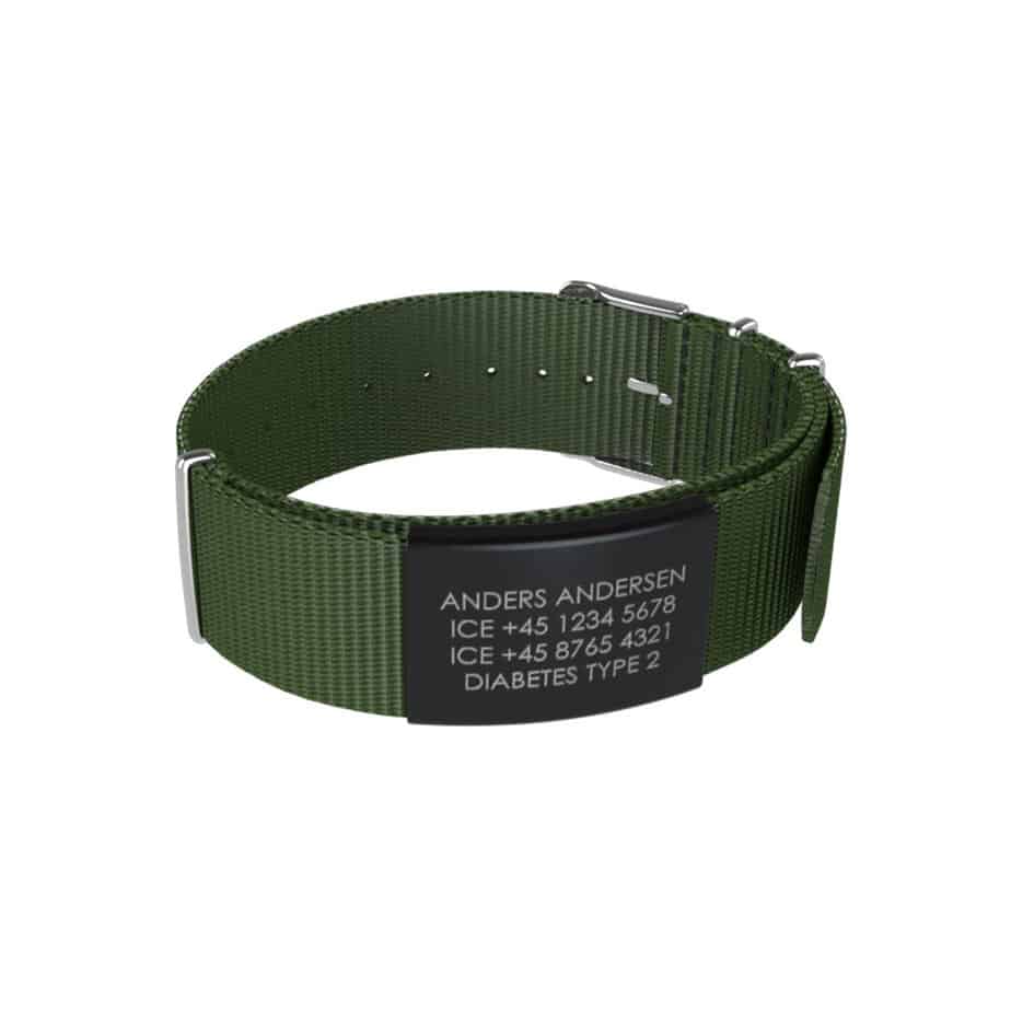 DJUVA Hit komplet armbånd: Grønt nylon ID-armbånd med sort graveret plade, der viser navn, telefonnumre og medicinske oplysninger.