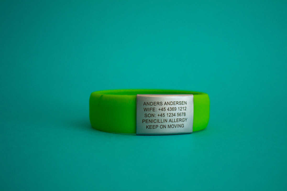DJUVA Stream ID armbånd: Limegrønt silikone ID-armbånd med indgraveret grå plade, der viser kontaktoplysninger og allergialarm.