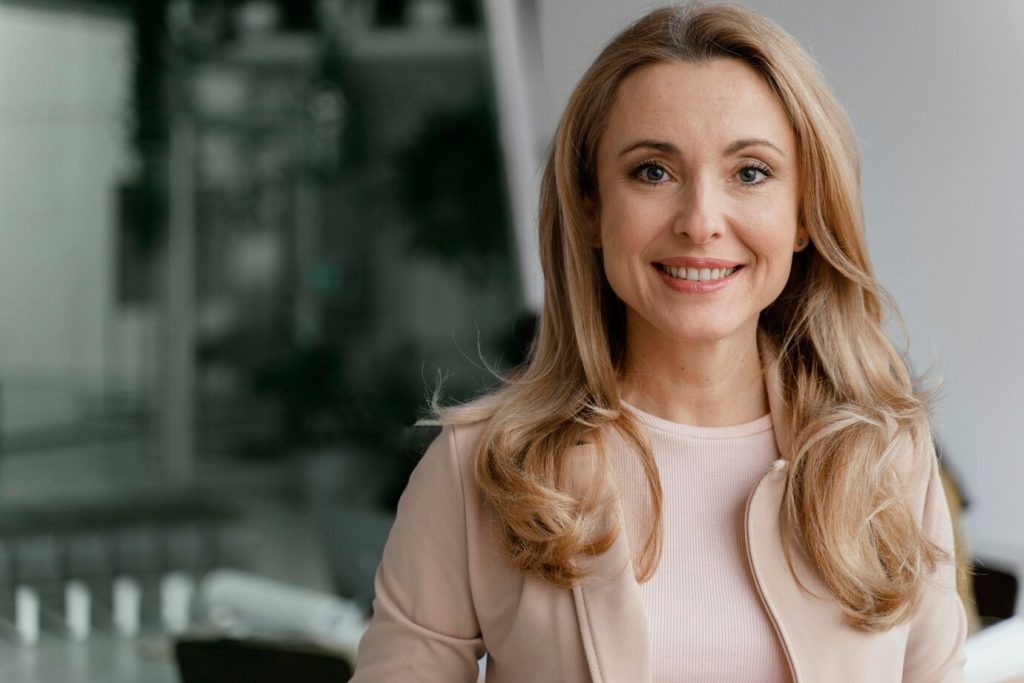 Przyjazny uśmiechnięty kobieta, ekspert ds. domu i ogrodu, w eleganckiej sukience, promująca produkty dla domu i ogrodu, profesjonalna obsługa klienta, nowoczesne rozwiązania dla domu.