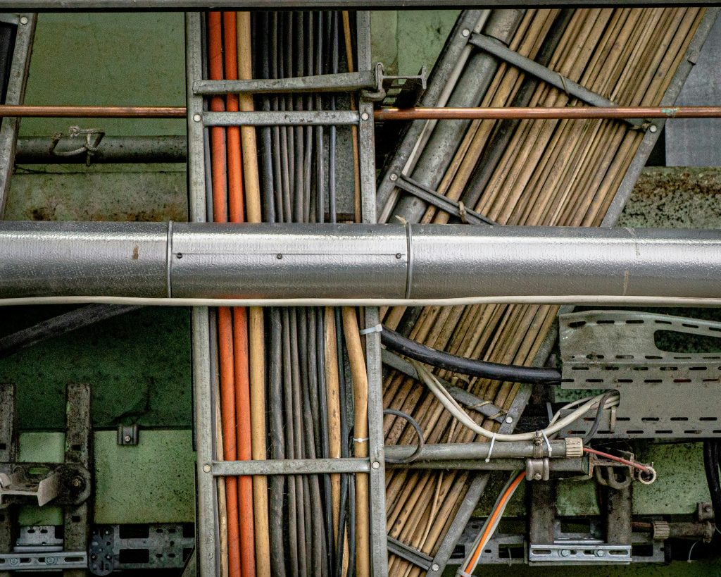Przewody elektryczne i instalacje w budynku, widok na rozdzielnię i okablowanie, elementy infrastruktury domu i ogrodu, profesjonalny montaż i serwis.