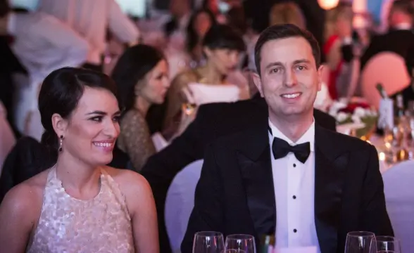 Elegancki mężczyzna i kobieta na weselu, uświetniając wydarzenie w eleganckim stroju, przy stole z winem, idealne na okazję ślubną, uroczystości rodzinne i eventy dla domu i ogrodu.