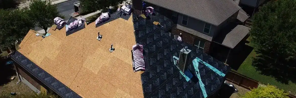 San Antonio home during a roofing project, showing a roof tear off process by Dolan Roofing & Construction with new underlayment and roofing materials prepared for installation.