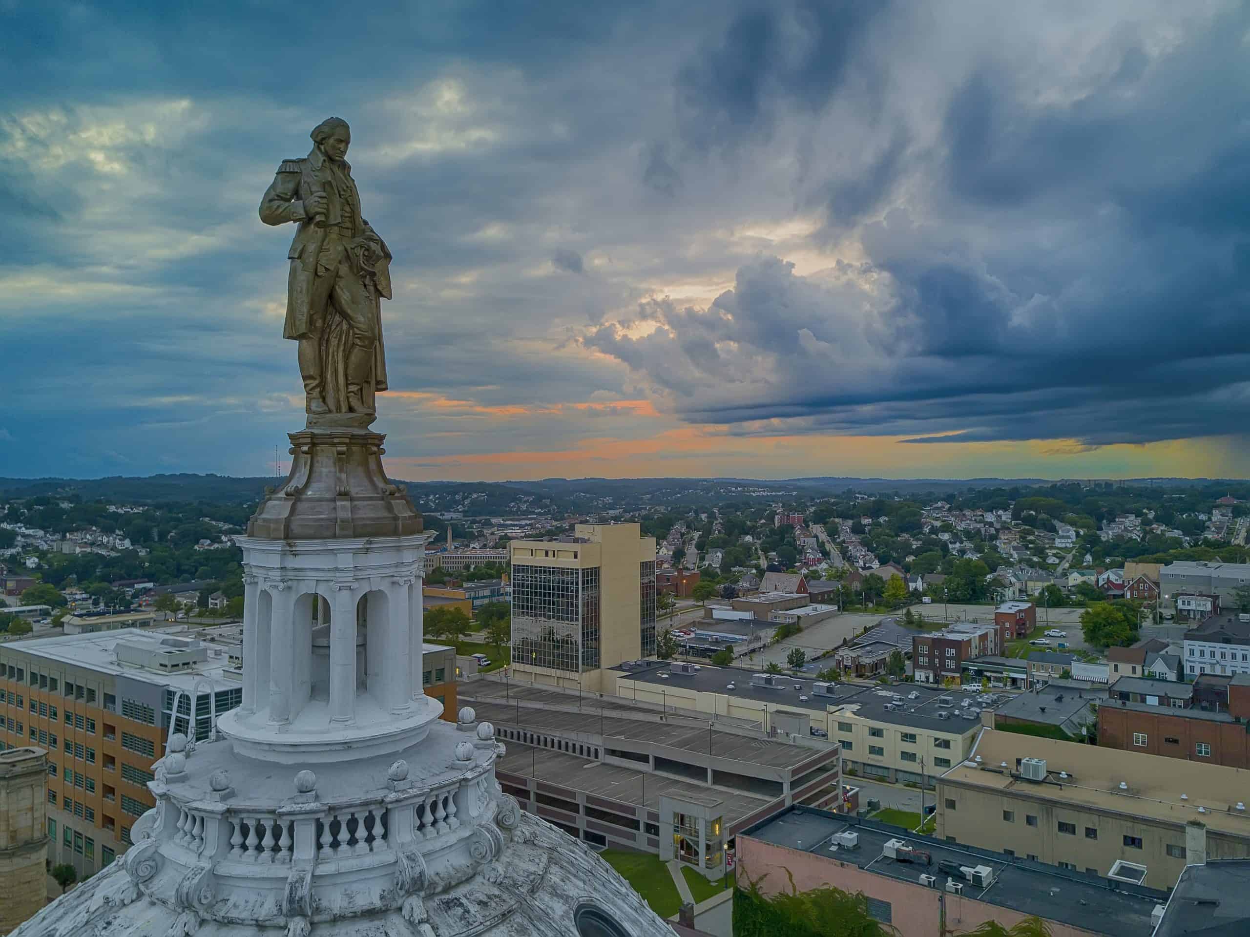 Statue of Liberty replica overlooking downtown Washington, Pennsylvania, at sunset.