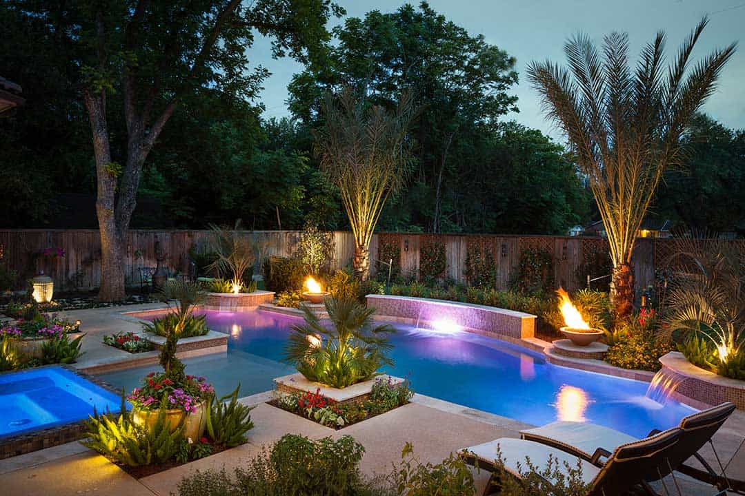 Luxury backyard pool with vibrant lighting and lush landscaping at dusk. Perfect for outdoor relaxation and entertaining in Australia.