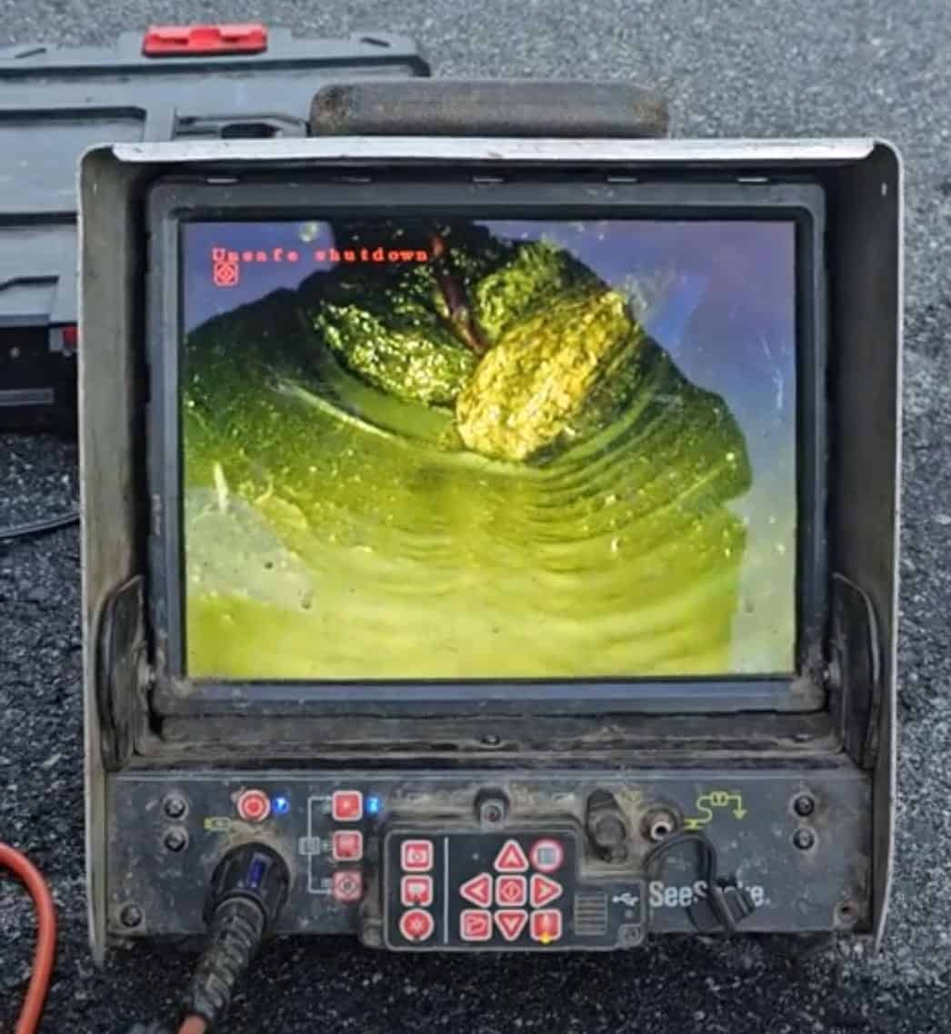 Technician inspecting a drain pipe with a specialized camera