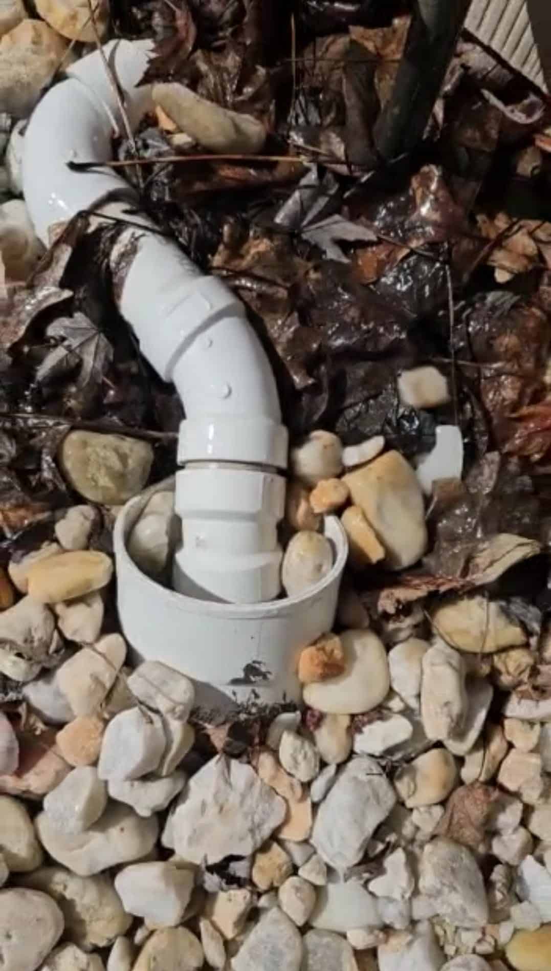 Technician repairing a clogged outdoor drainage system