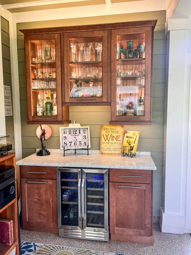 Custom built-in bar cabinetry with glass upper cabinets and wine refrigerator