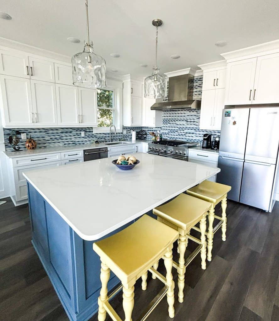 Modern black kitchen island with white countertops and pendant lighting