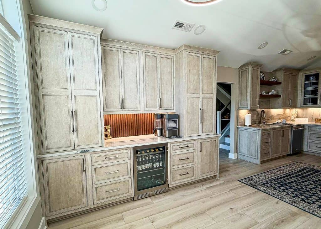 Custom range hood with stone backsplash and gray kitchen cabinets