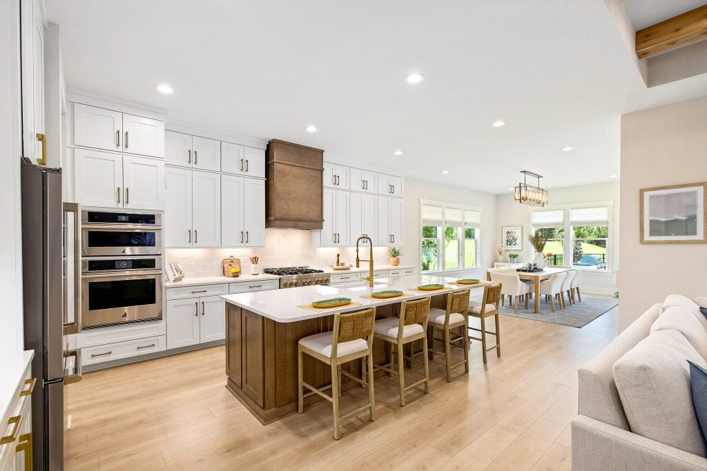 White custom kitchen cabinets with wood island and bar seating