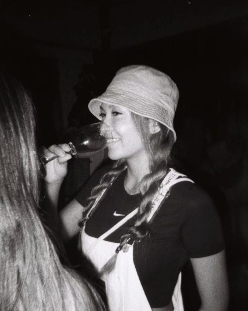Woman enjoying a glass of wine, smiling.