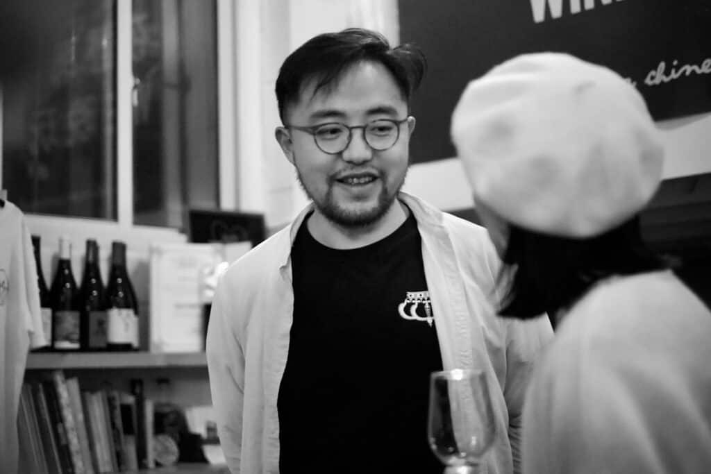 Two people talking in a wine bar, black and white.