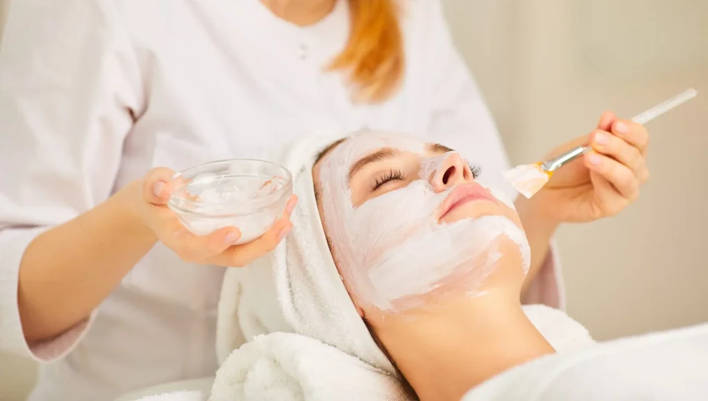 Woman receiving facial beauty treatment at spa.