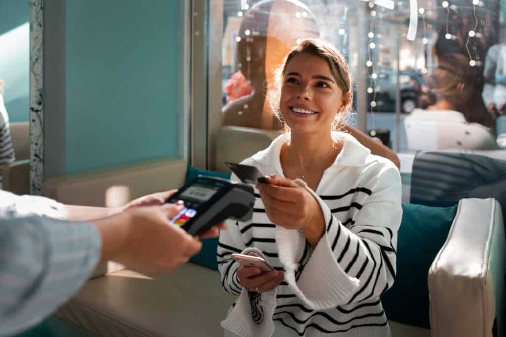 Woman paying with credit card in cafe