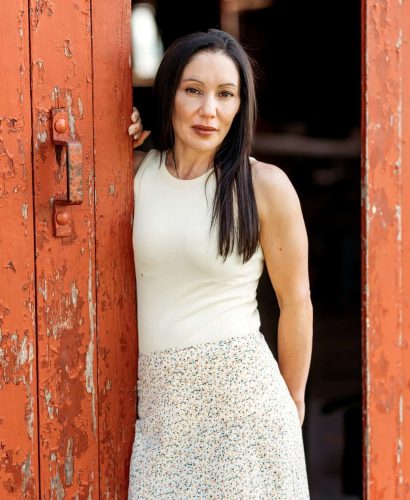 Woman standing by rustic red door