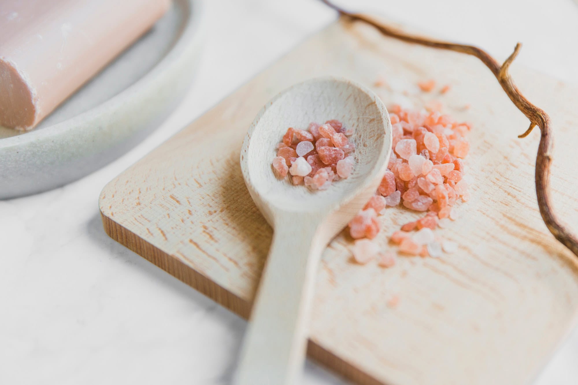 Pink Himalayan salt crystals on a wooden spice board with natural ingredients at Sanjivani Ayurved Shala.
