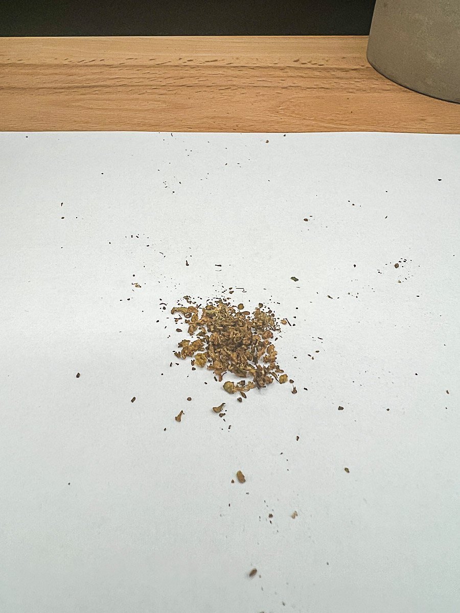 Ground dry herb on white surface with wooden background – POTV Lobo Review 2025 session prep