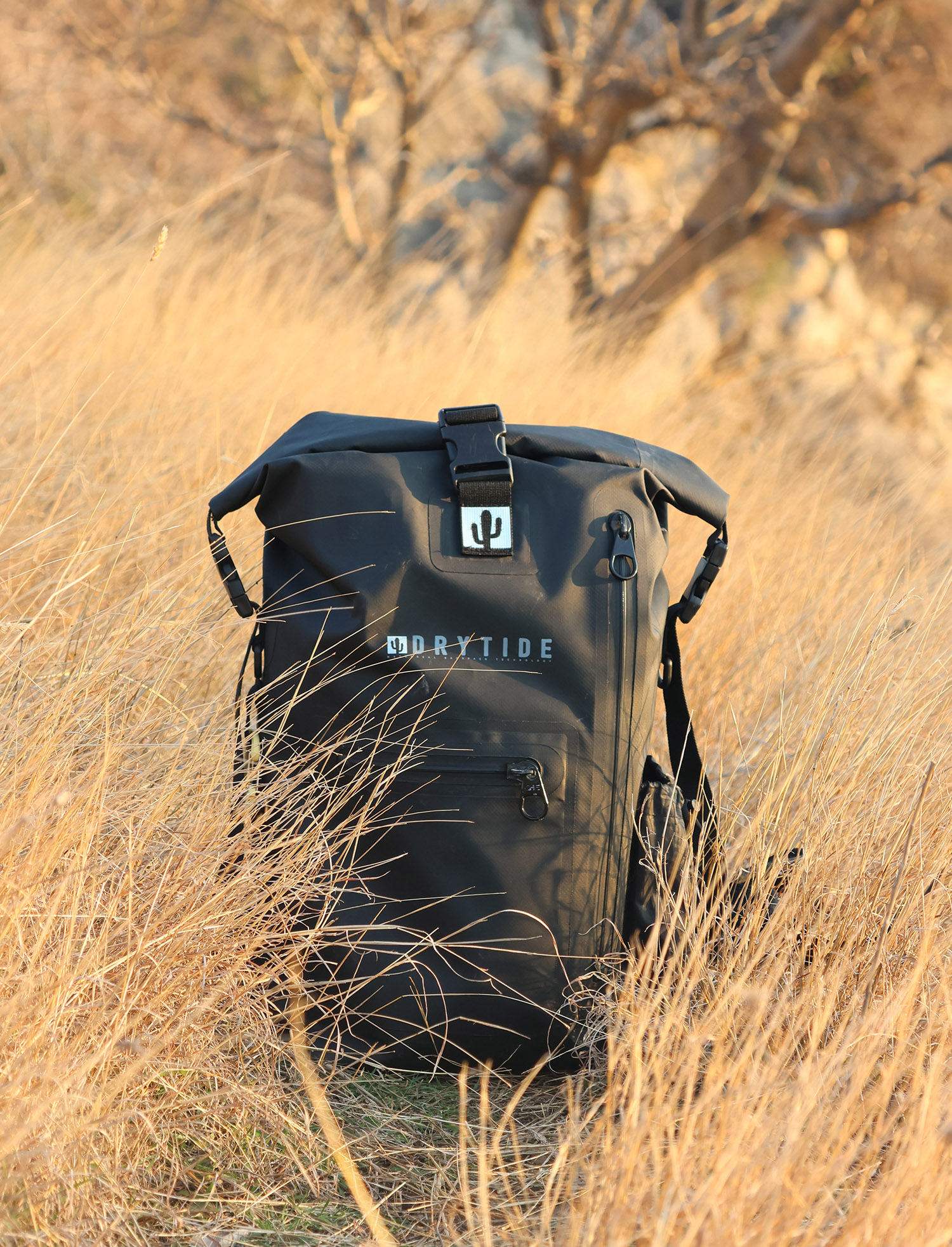 Waterproof dry bag backpack in outdoor grassland setting for adventure travel.