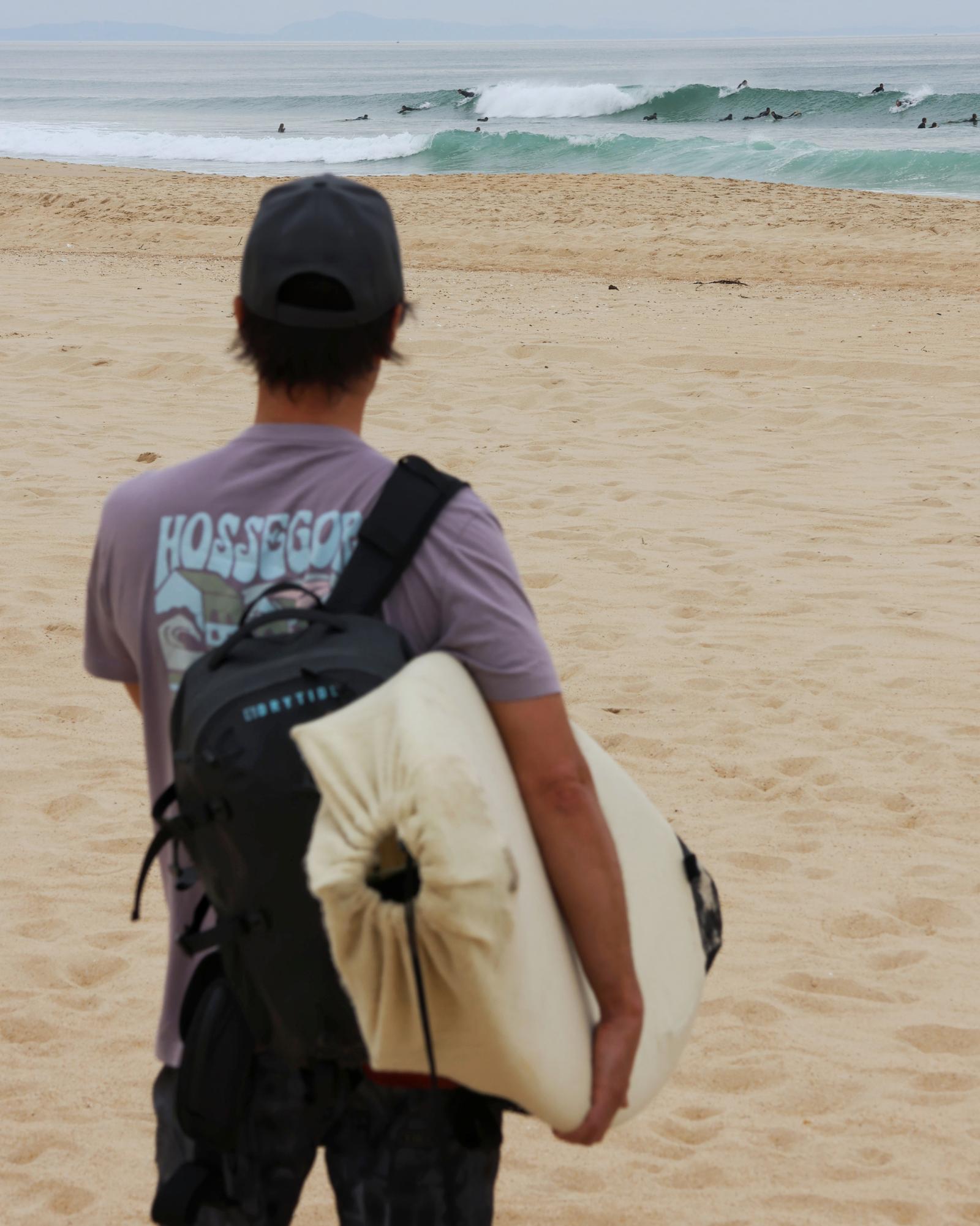 Surfer with Point Nemo airtight backpack on a surf trip Surfer with Point Nemo airtight backpack on a surf trip