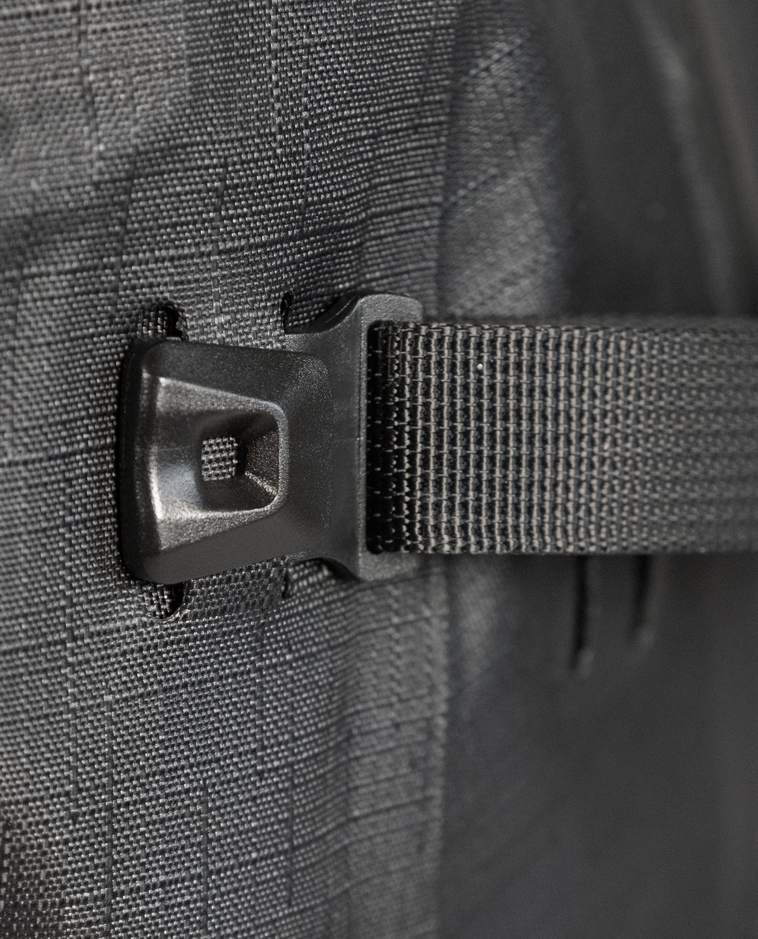 Close-up of waterproof backpack buckle and strap detail.