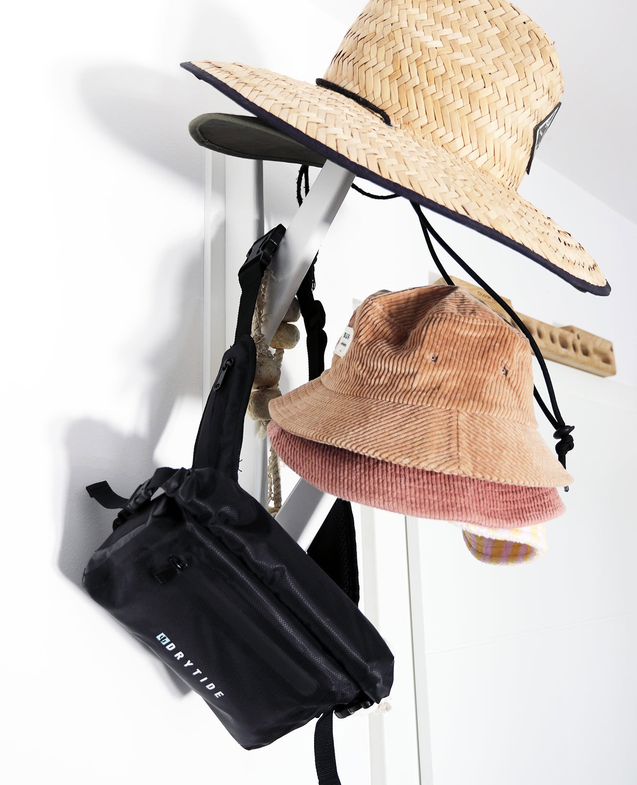 Waterproof Waist Bag 2.0 Waterproof waist bag hanging with hats and accessories, ideal for outdoor activities.