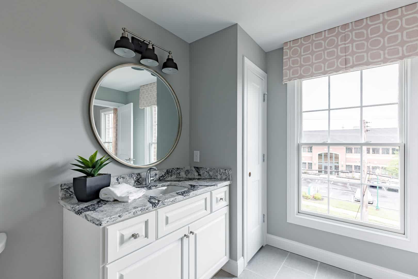 round mirror above white bathroom vanity