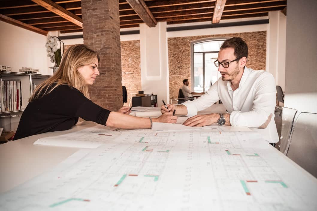 a man and a woman looking over a blueprint together