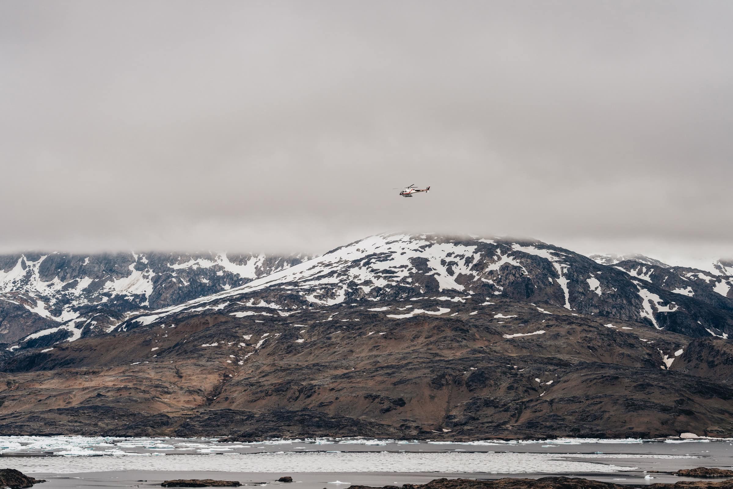 Helicopter approaching in foggy weather. Photo by Filip Gielda - Vist East Greenland
