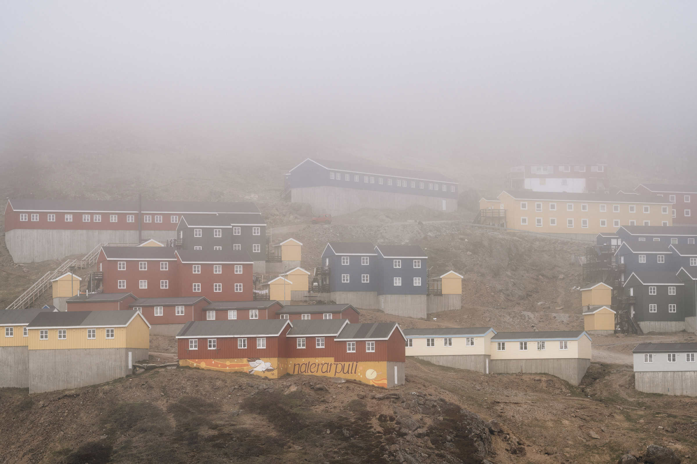 Houses disappearing in fog. Photo Filip Gielda - Visit East Greenland