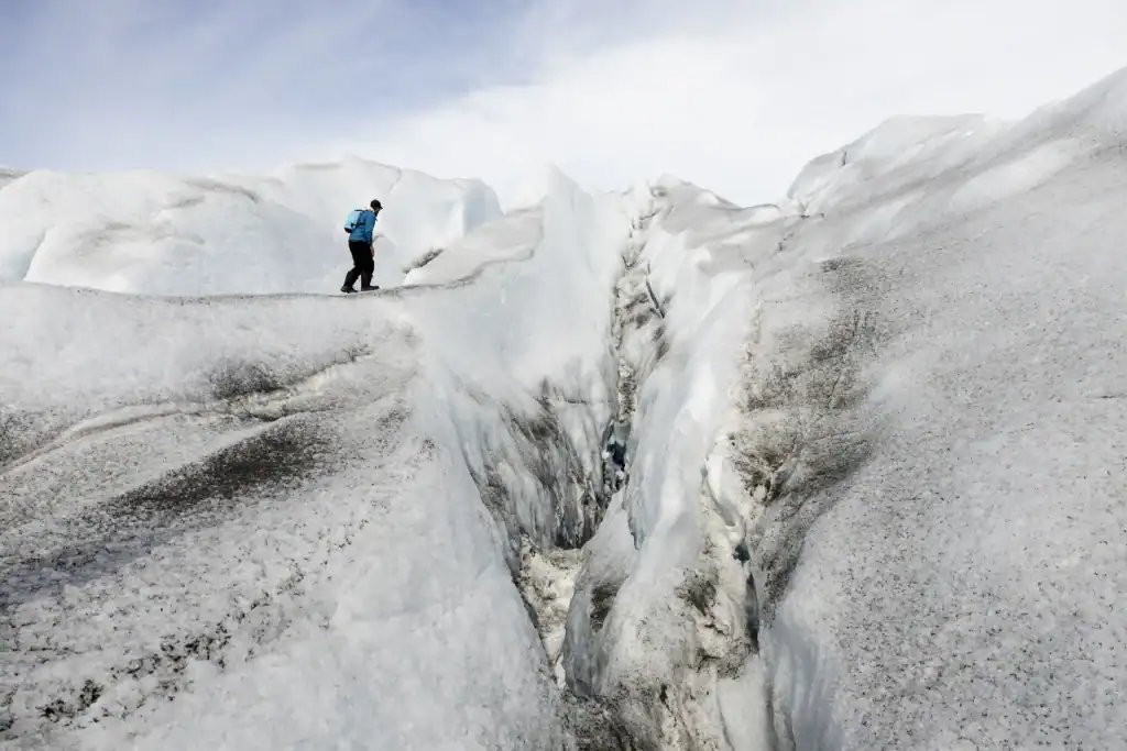 Adventurer walking along a glacial crevasse in East Greenland.