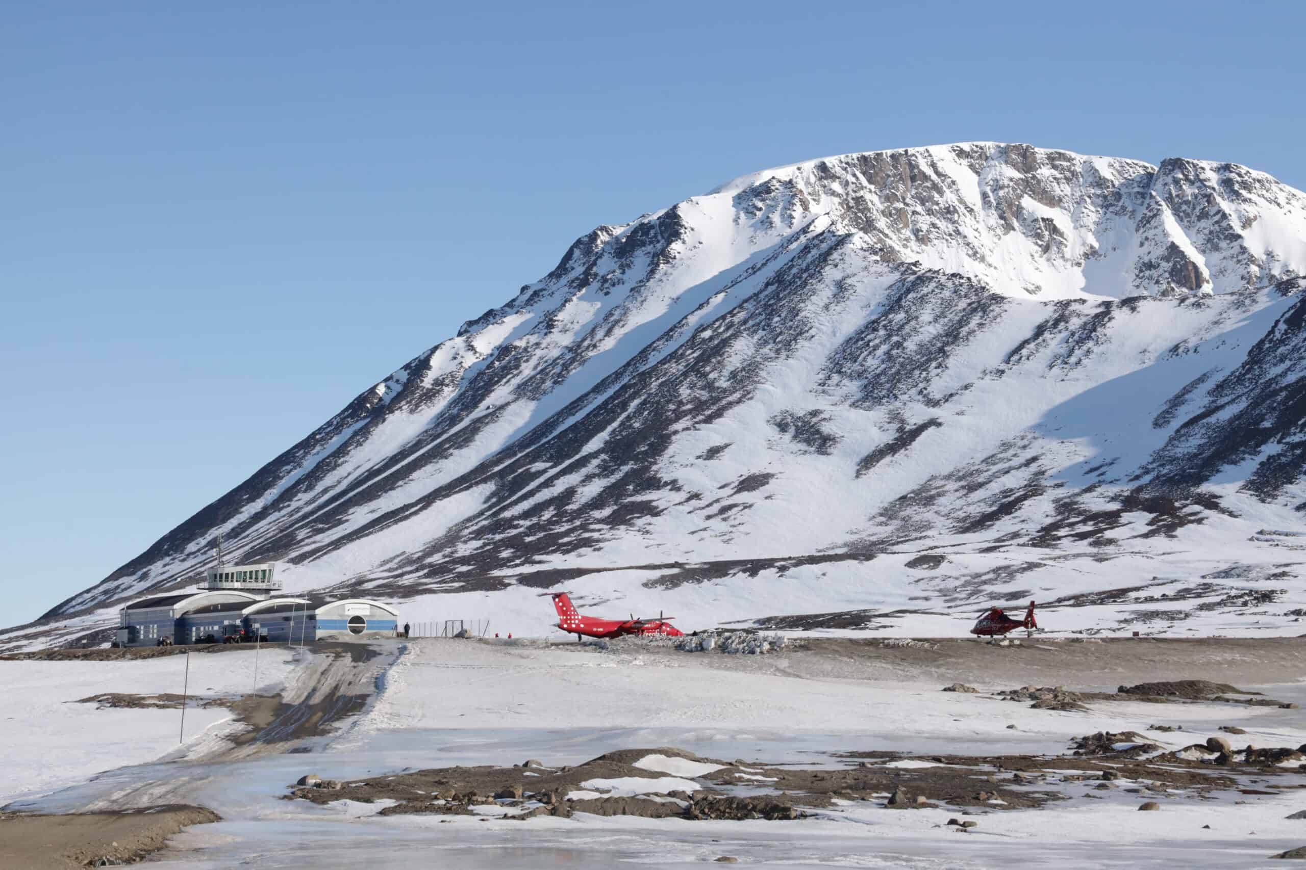 Air Greenland Dash 8 and helicopter at Kulusuk airport during spring time.