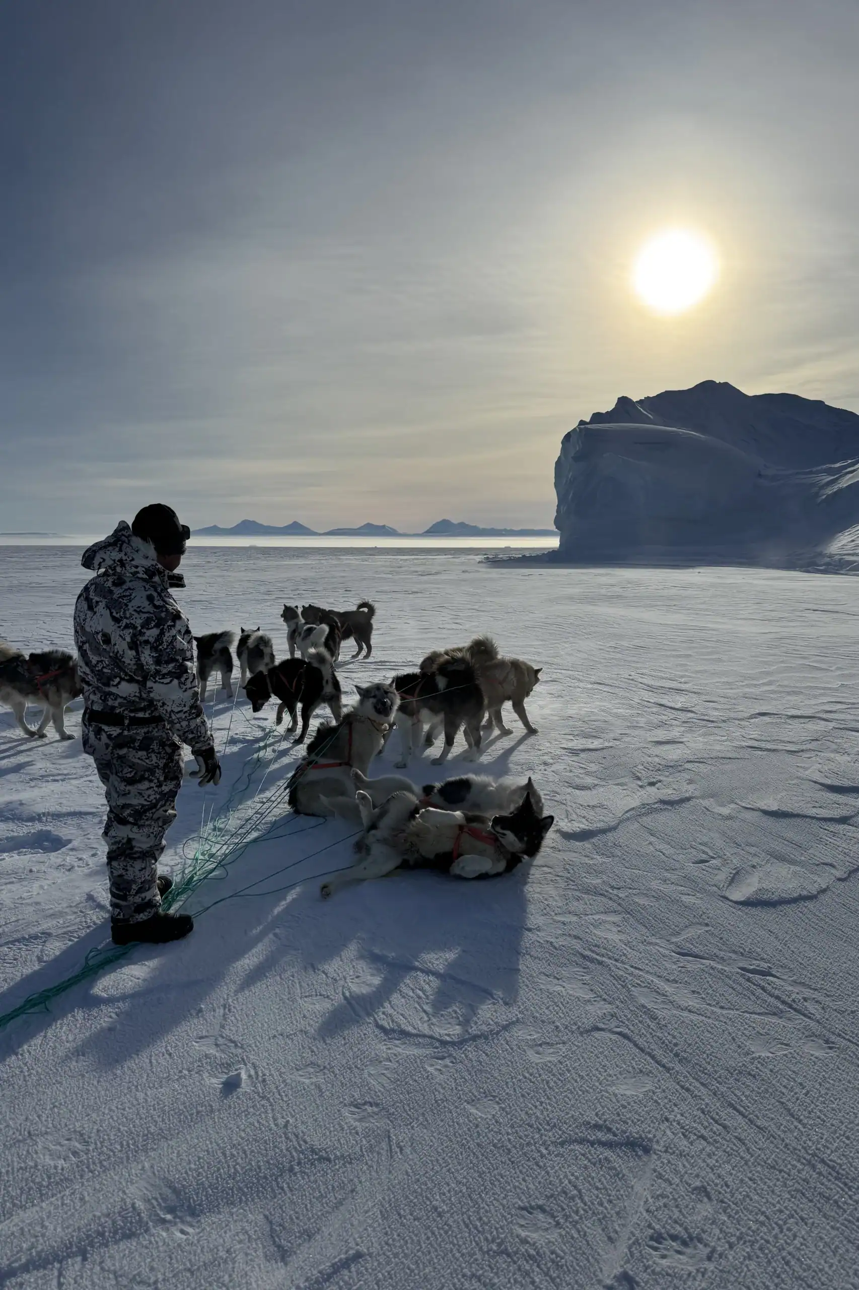 Taking a break next to an iceberg frozen into the sea ice in Scoresbysund.
