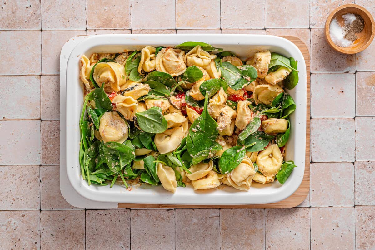 this shows me adding the spinach to the ceramic pan 