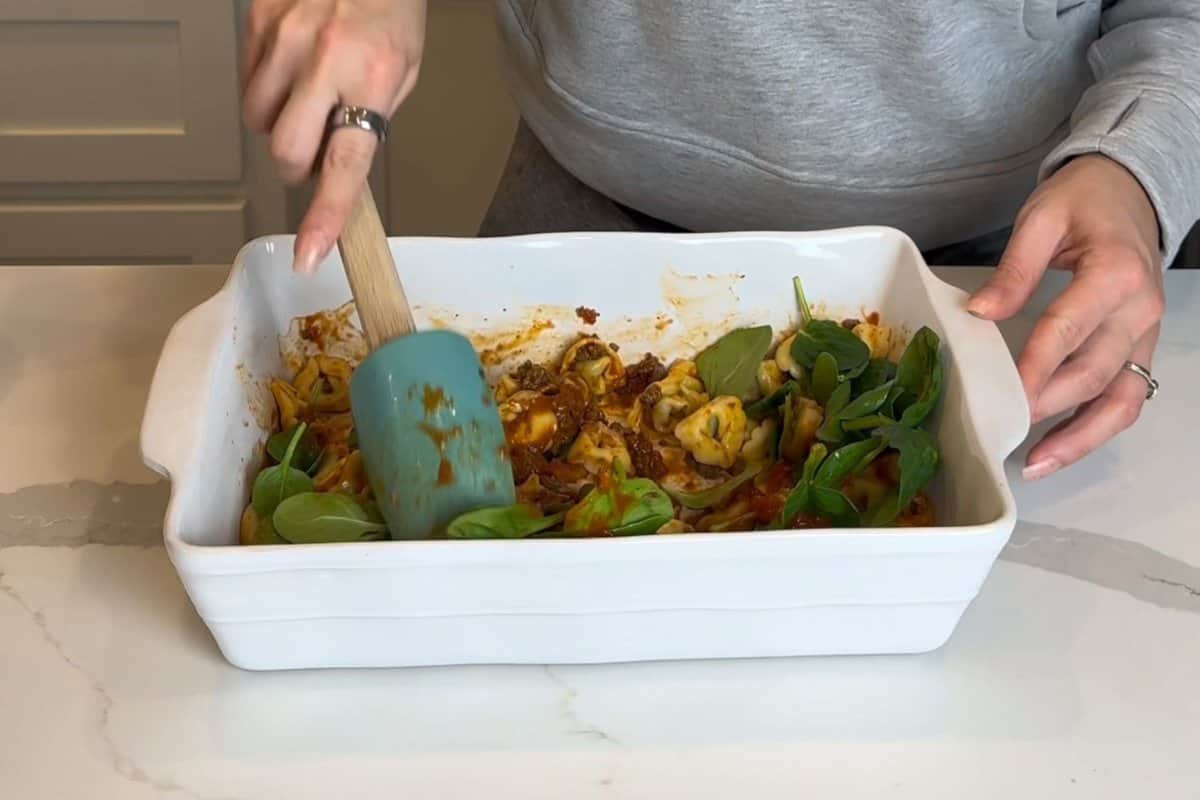step 4 shows me mixing the tortellini with marinara sauce, ground beef and fresh spinach in a ceramic baking dish.