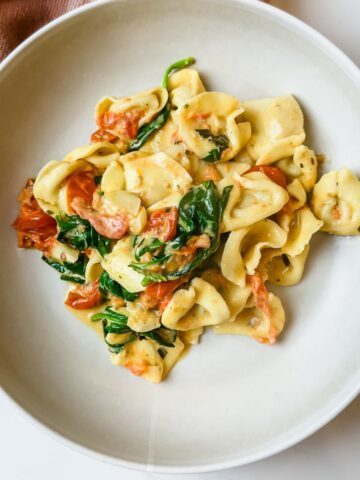 plate of baked tortellini with tomatoes and boursin cheese