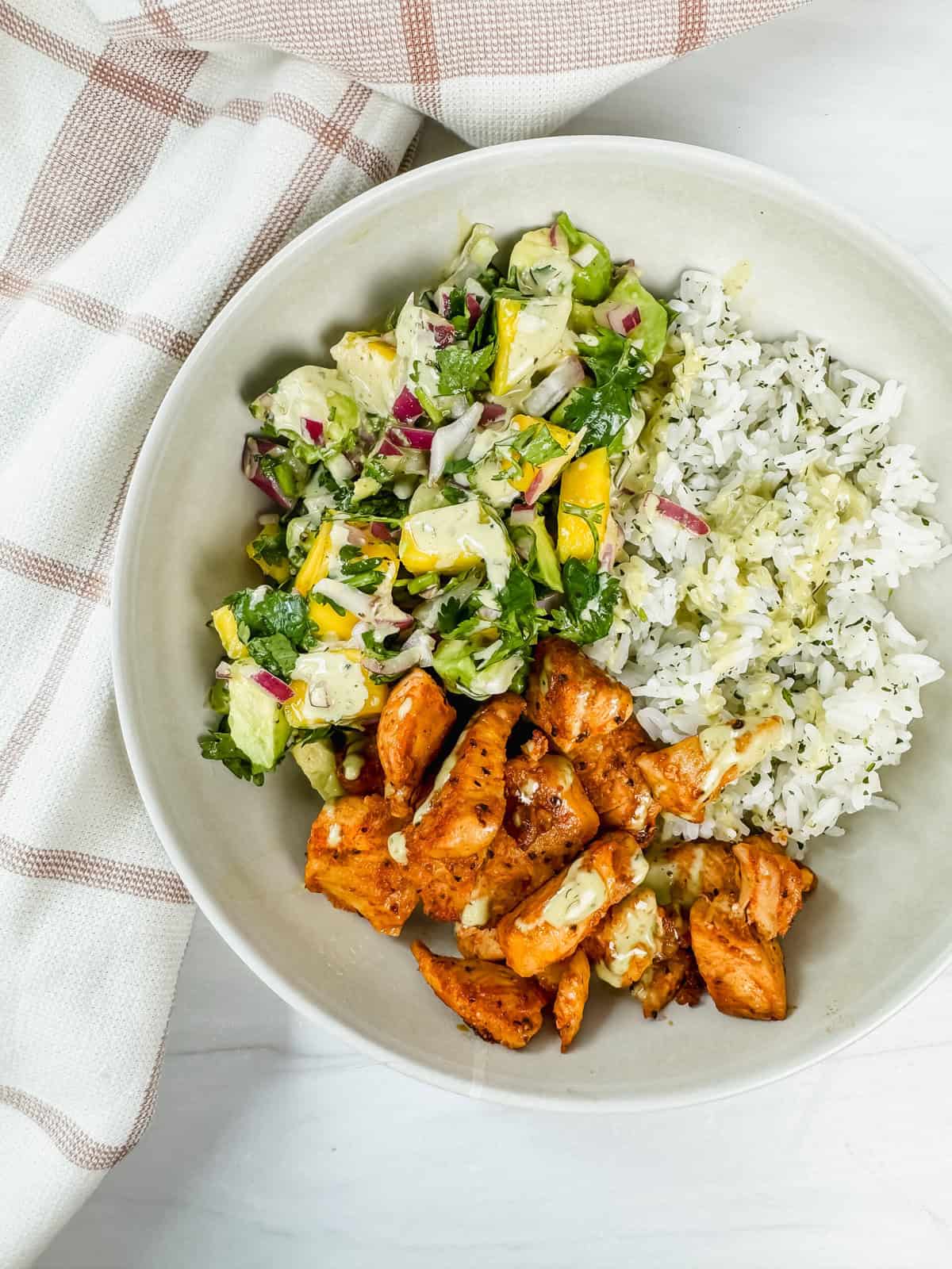 This is a close up view of my blackened chicken with mango salsa and cilantro lime rice on top of a kitchen towel.
