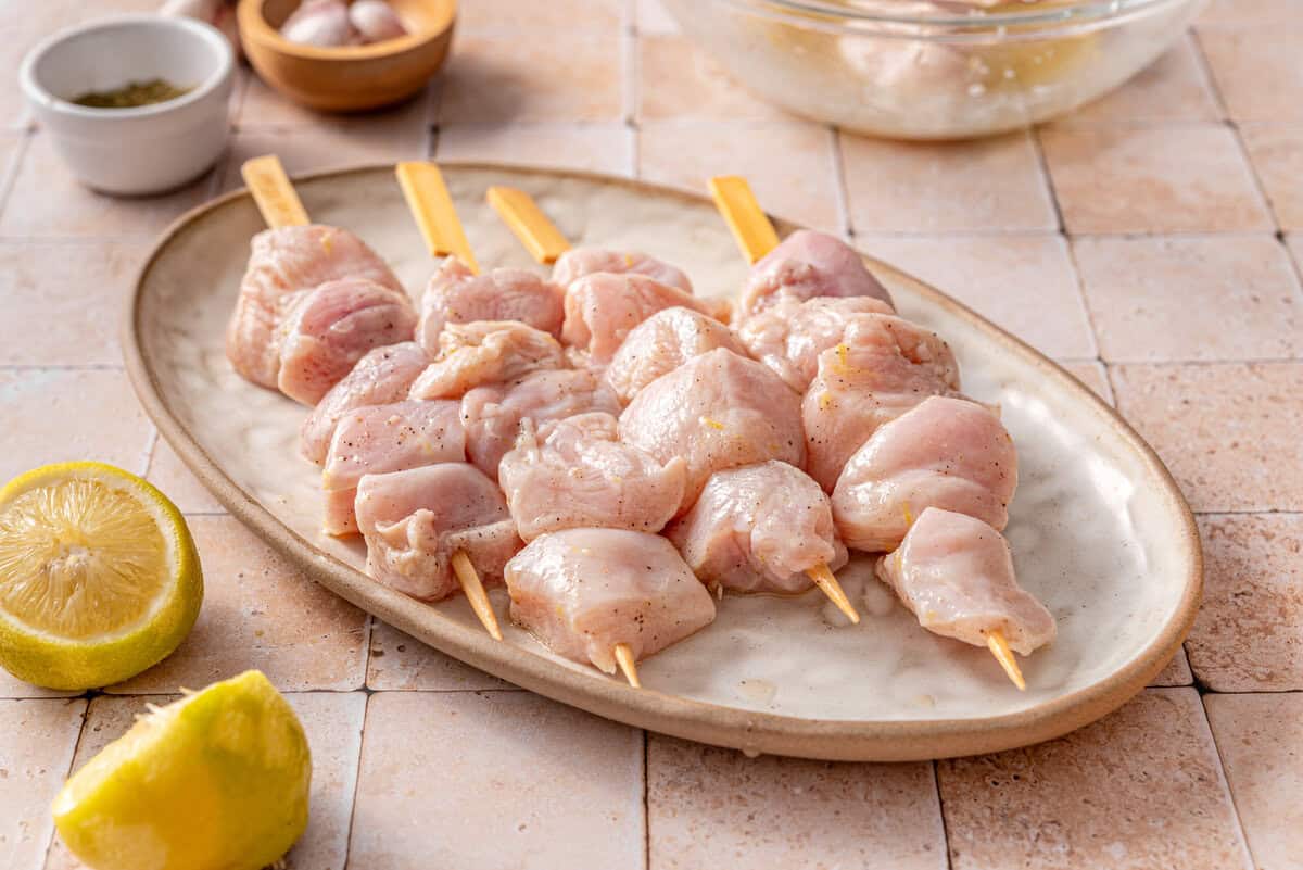 this shows me adding the chicken cubes on to a skewer 