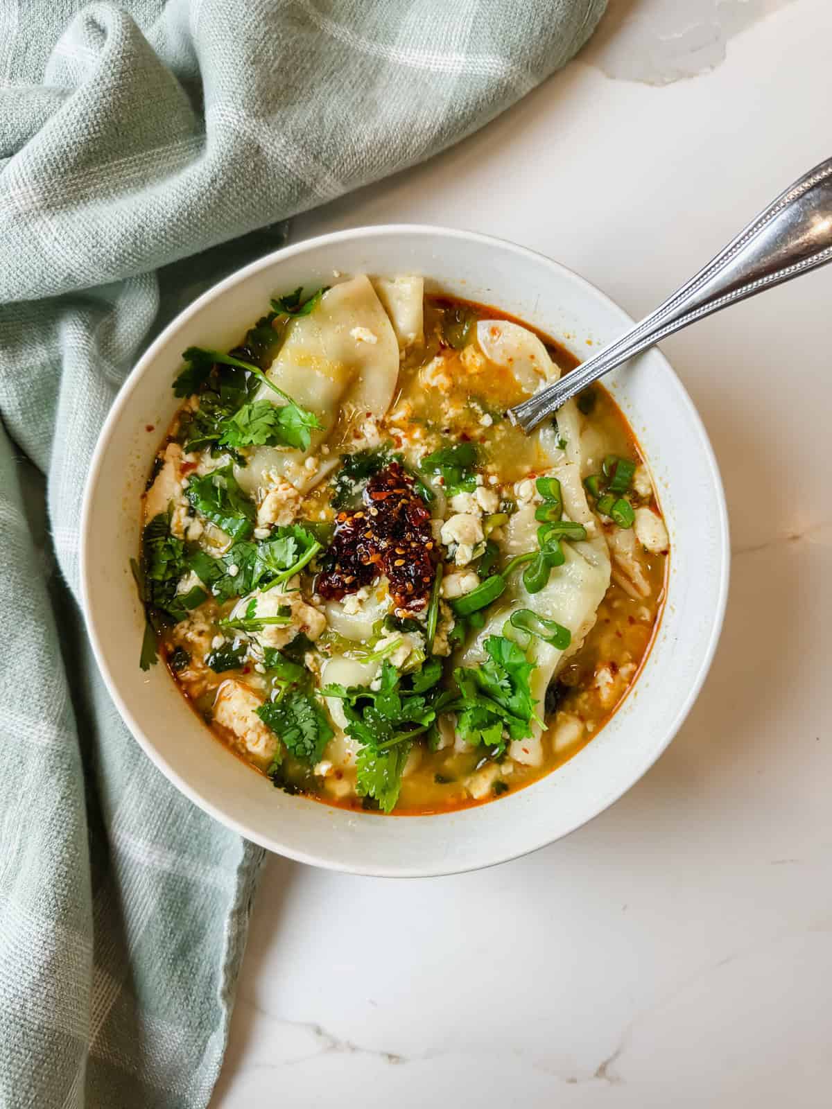This is a top view of my higher protein easy viral gyoza soup with chili crunch in the middle in a bowl. 