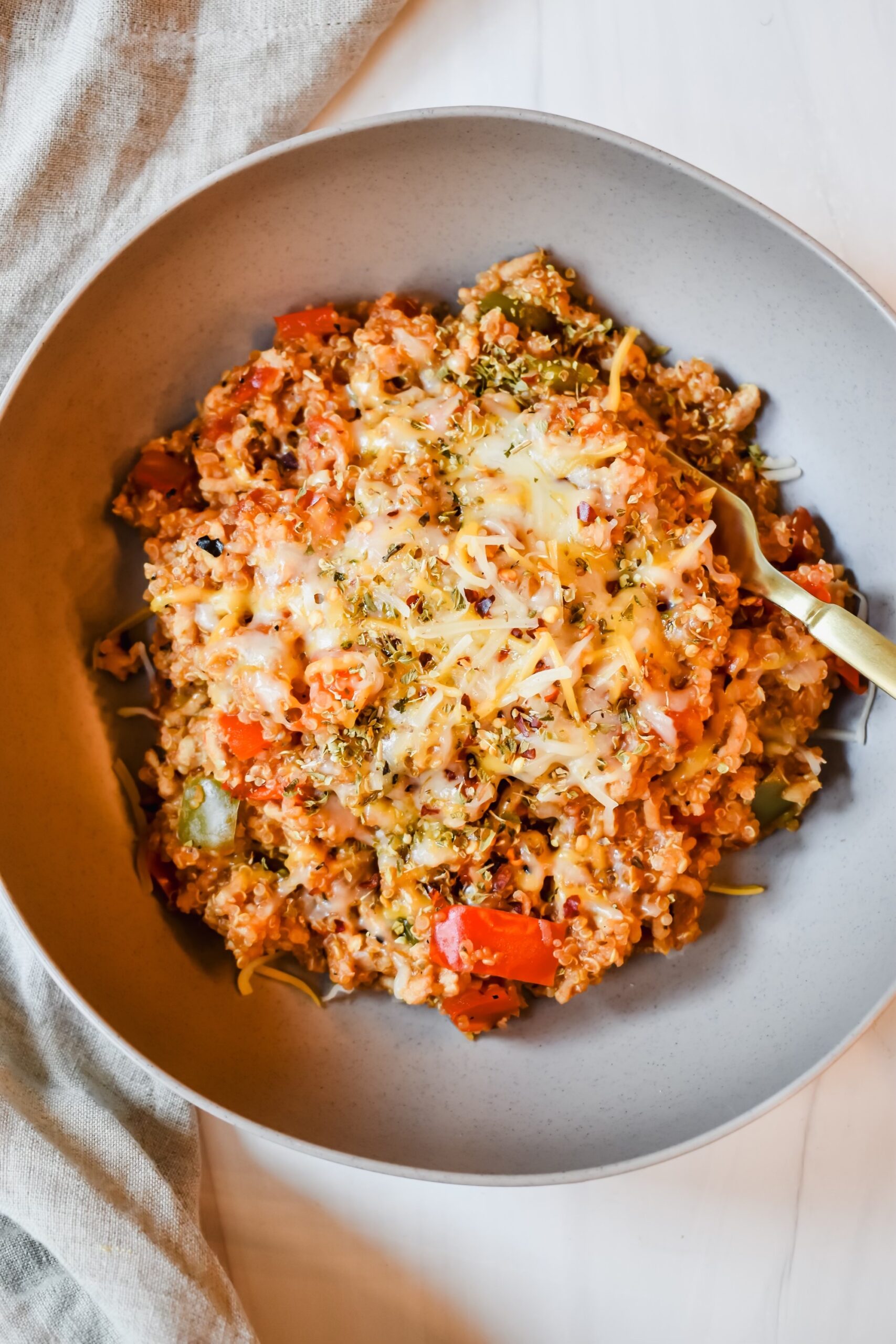 This is a top view of my unstuffed pepper skillet in a plate topped with shredded cheese and red pepper flakes
