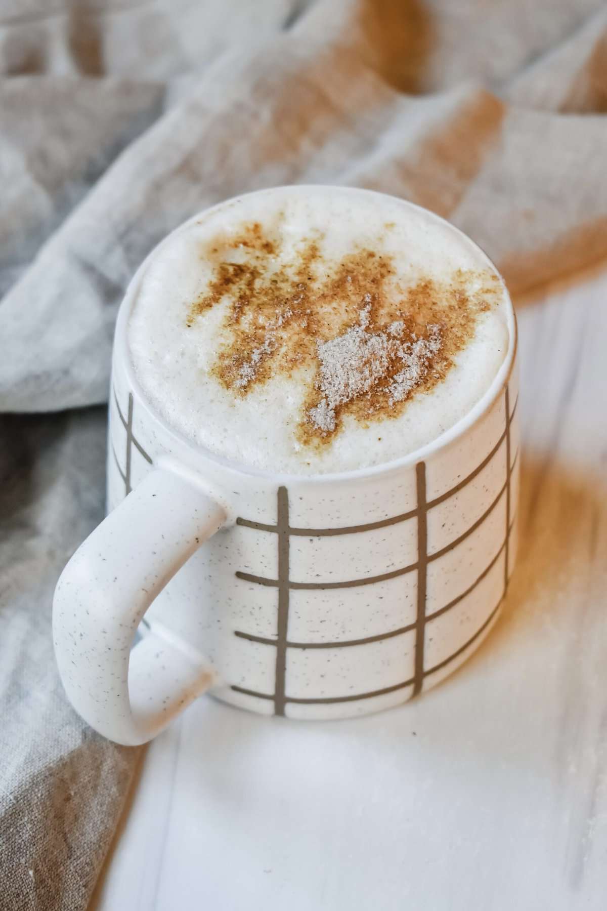 This is a close up of my dirty chai latte in a fall looking mug with chai powder sprinkled on top. 