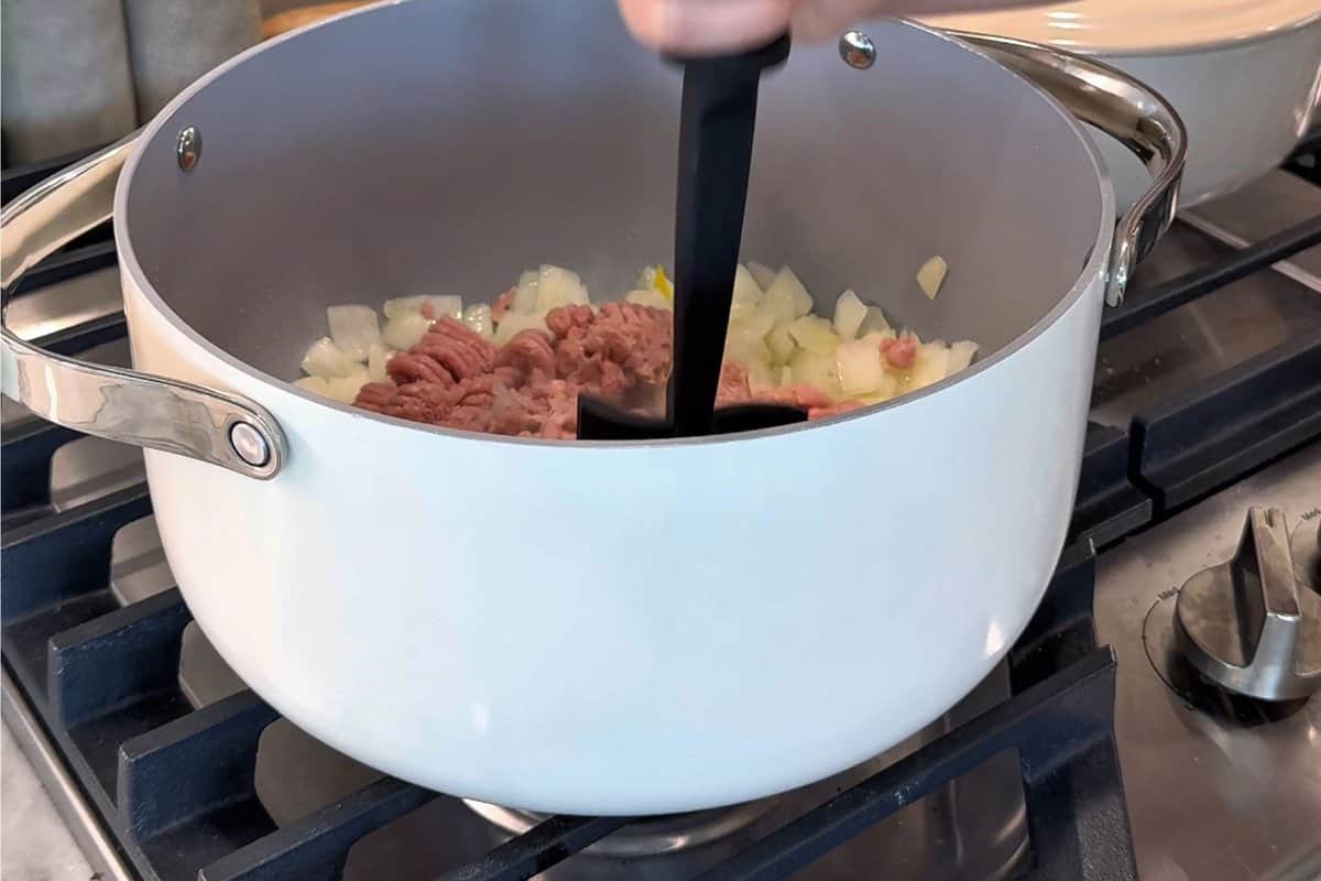 this shows me mashing the turkey and cooking it with the onions