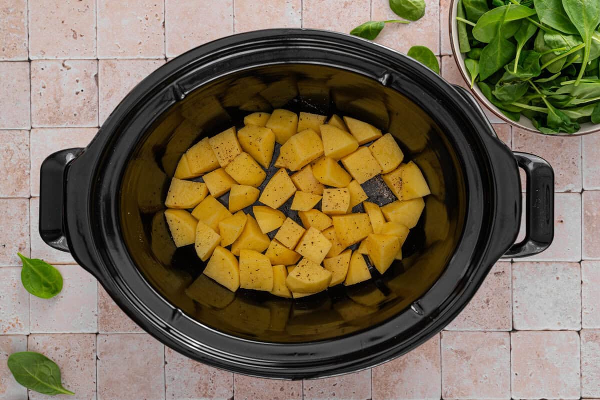 this shows the diced potatoes in a slow cooker