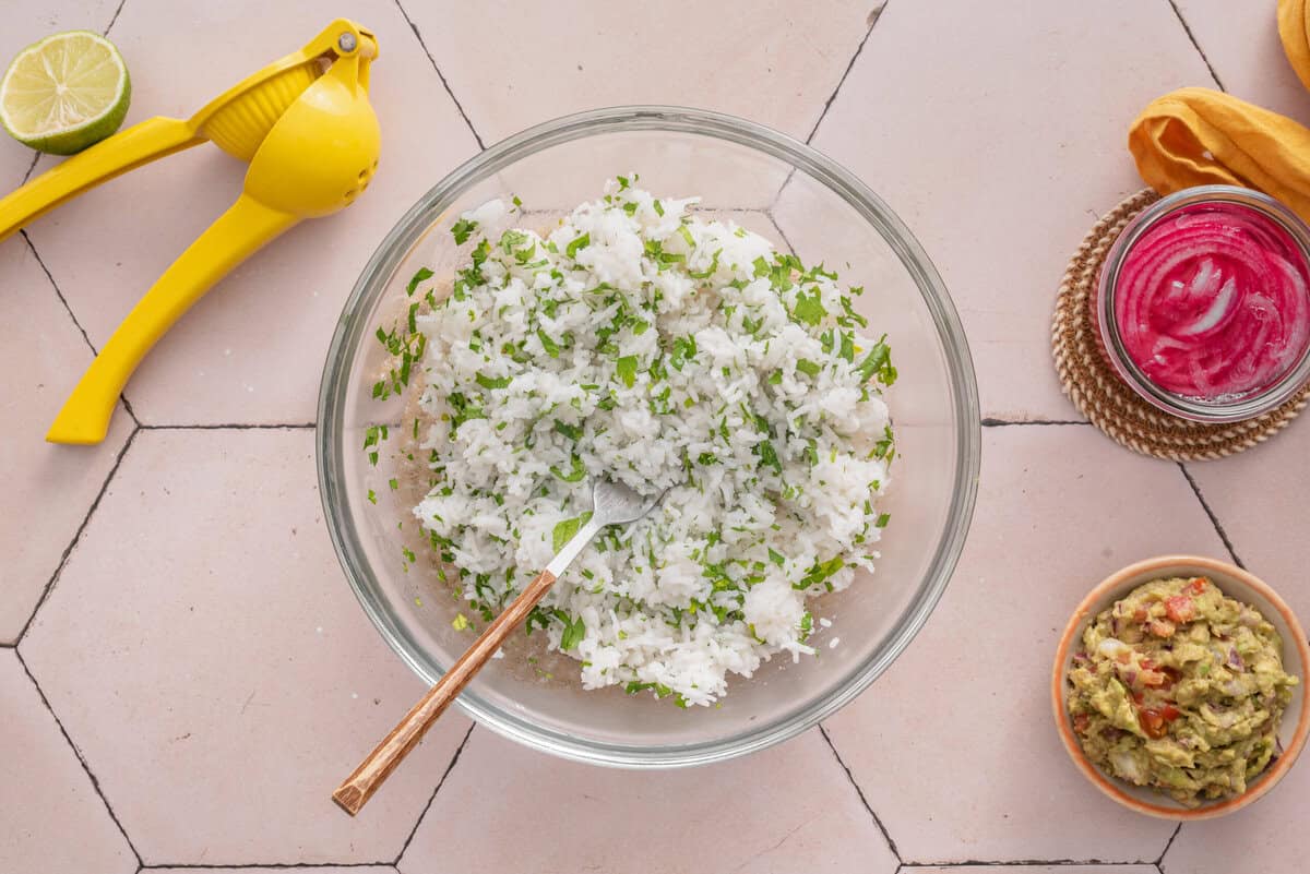 this shows me mixing fluffed cooked rice with lime and cilantro