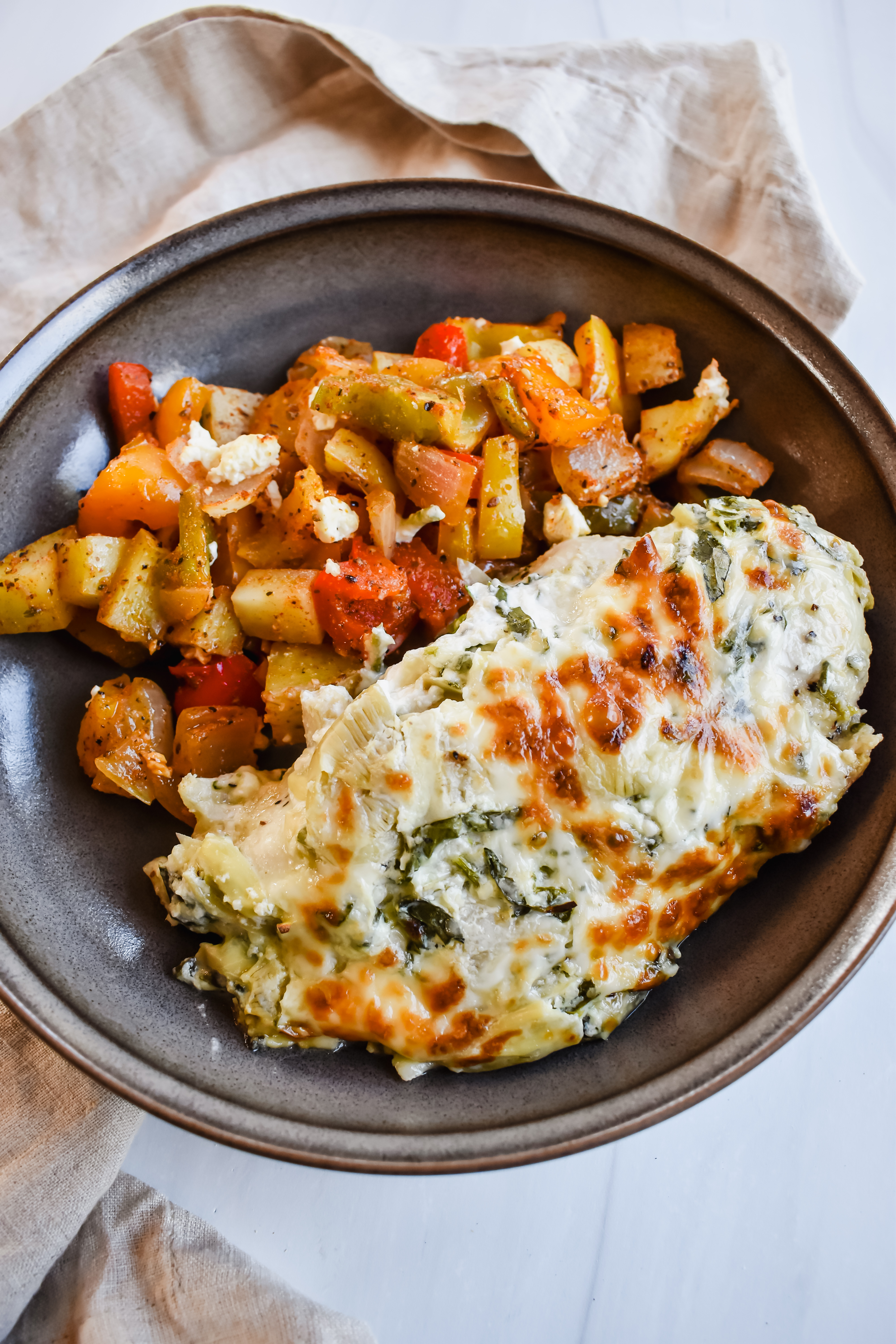 this is a side view close up of my spinach artichoke chicken bake with roasted vegetables.