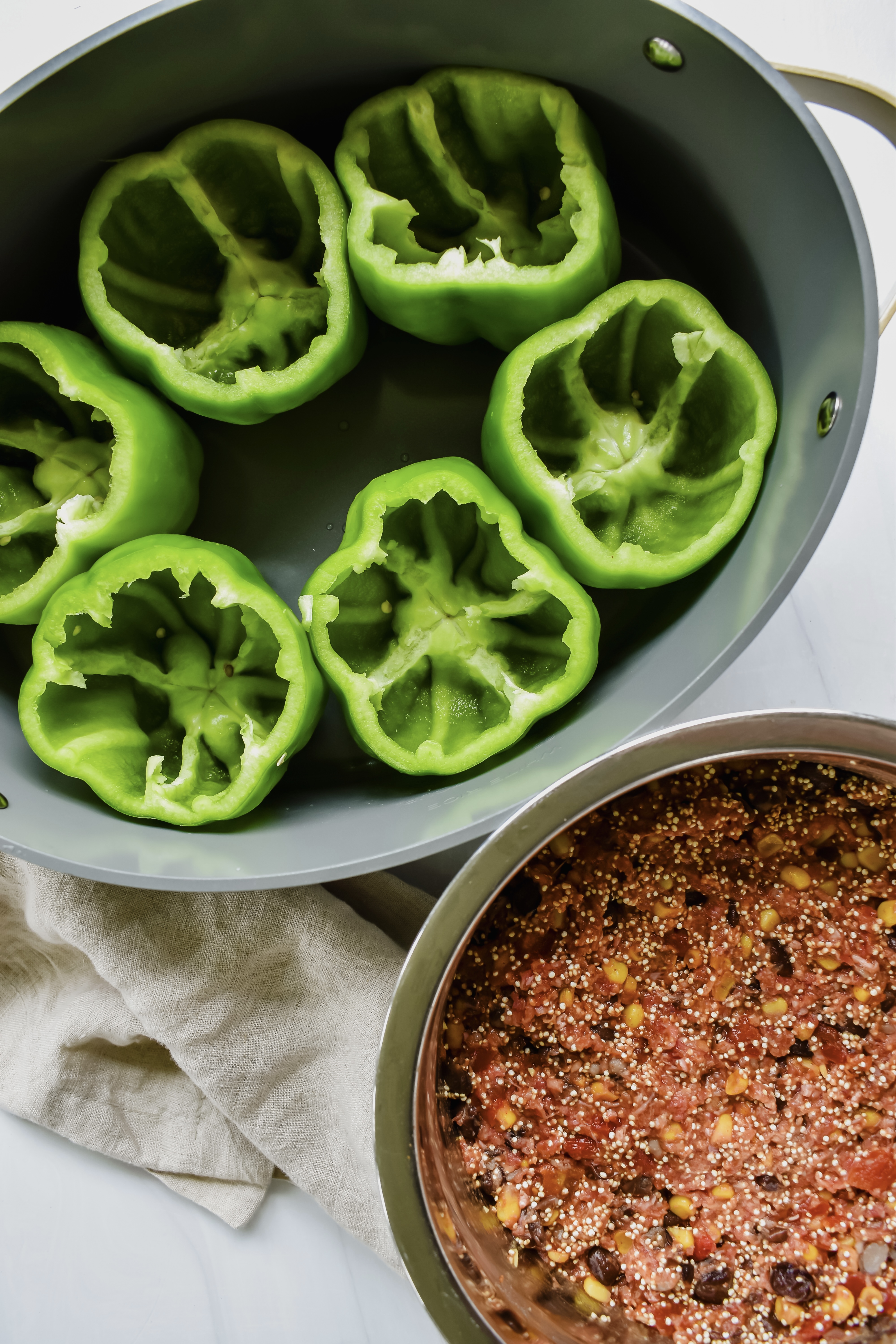 this is a top view of the meat and quinoa mixture in a bowl and the unstuffed peppers. 