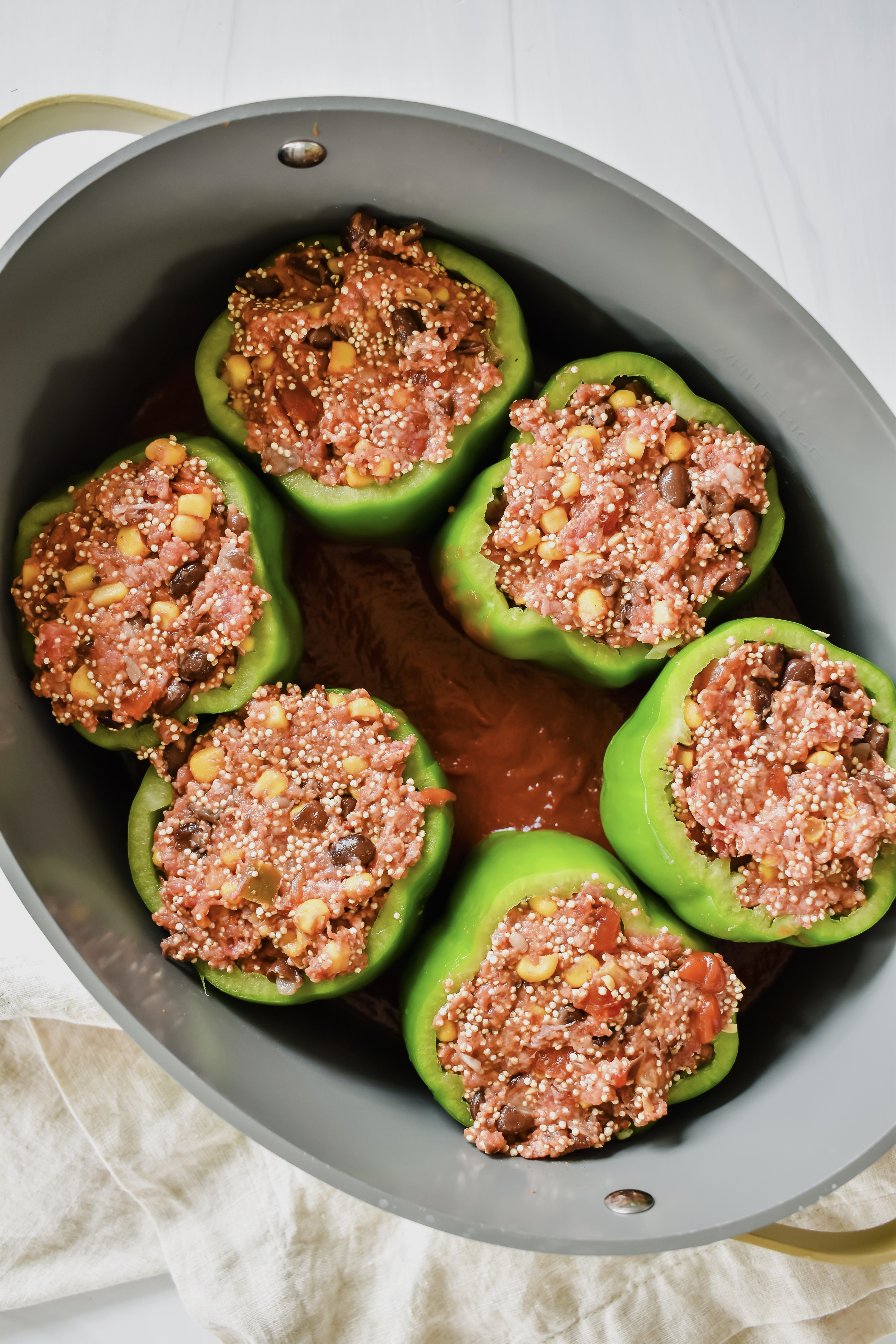 this shows the stuffed peppers in the crockpot with the tomato sauce. 