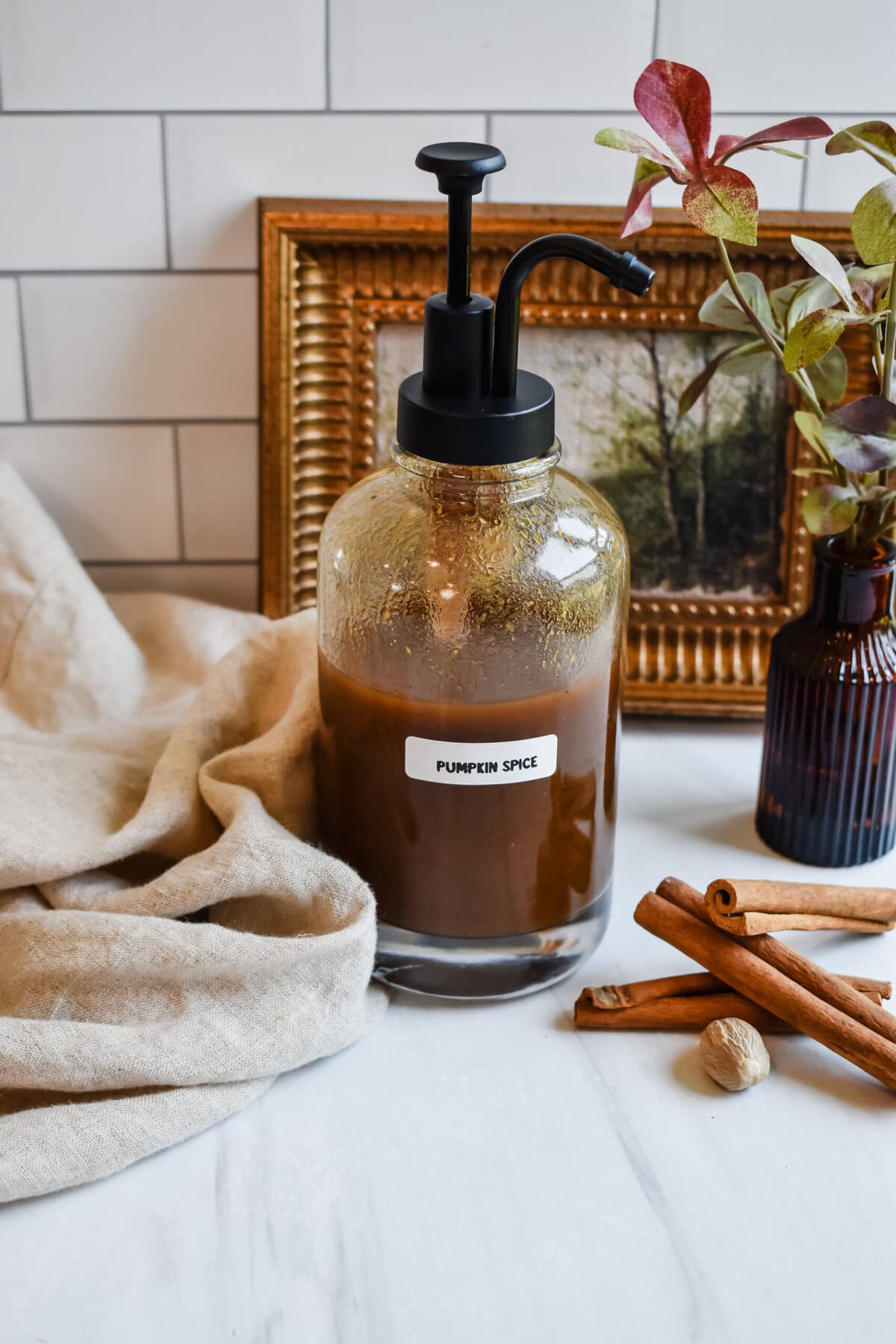 this is a side view of my sugar free pumpkin spice syrup with a fall backdrop 