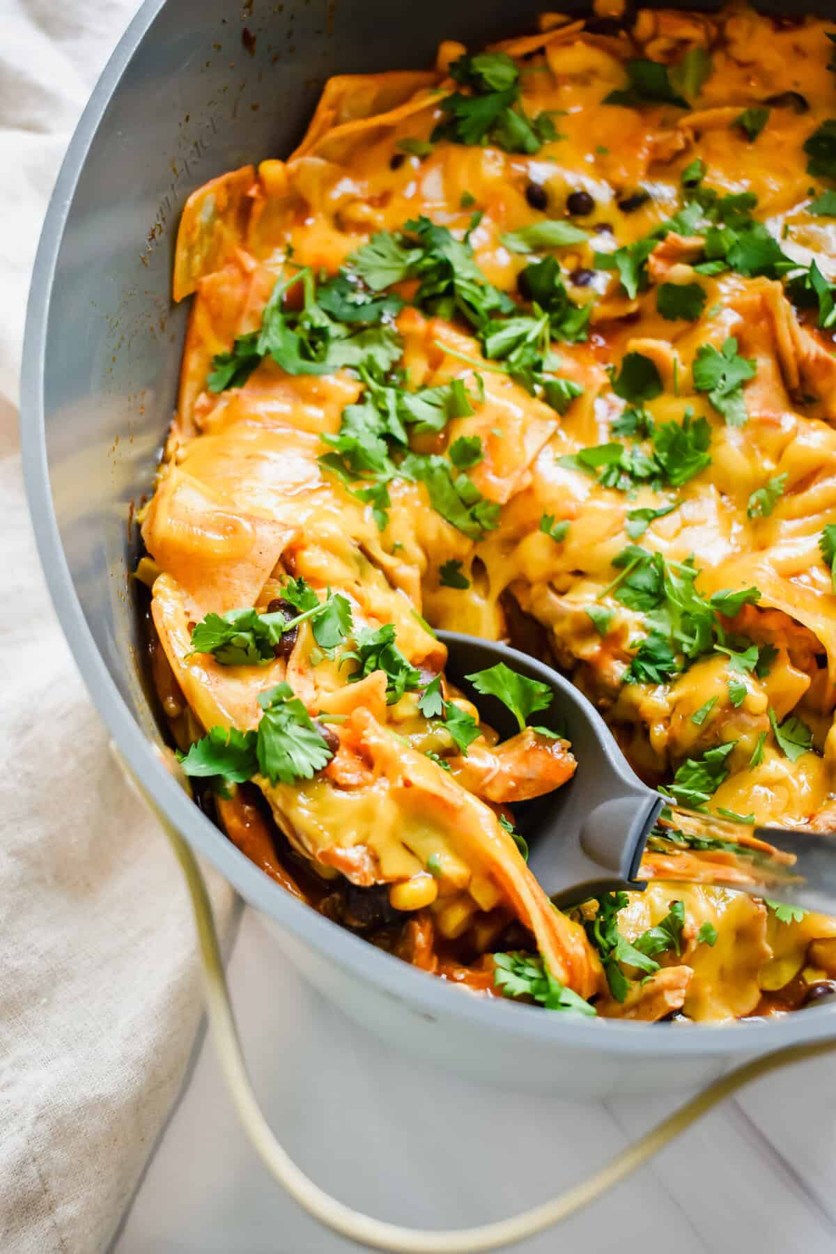 this is a close up of my slow cooker enchiladas in the crockpot with me scooping a serving out. 