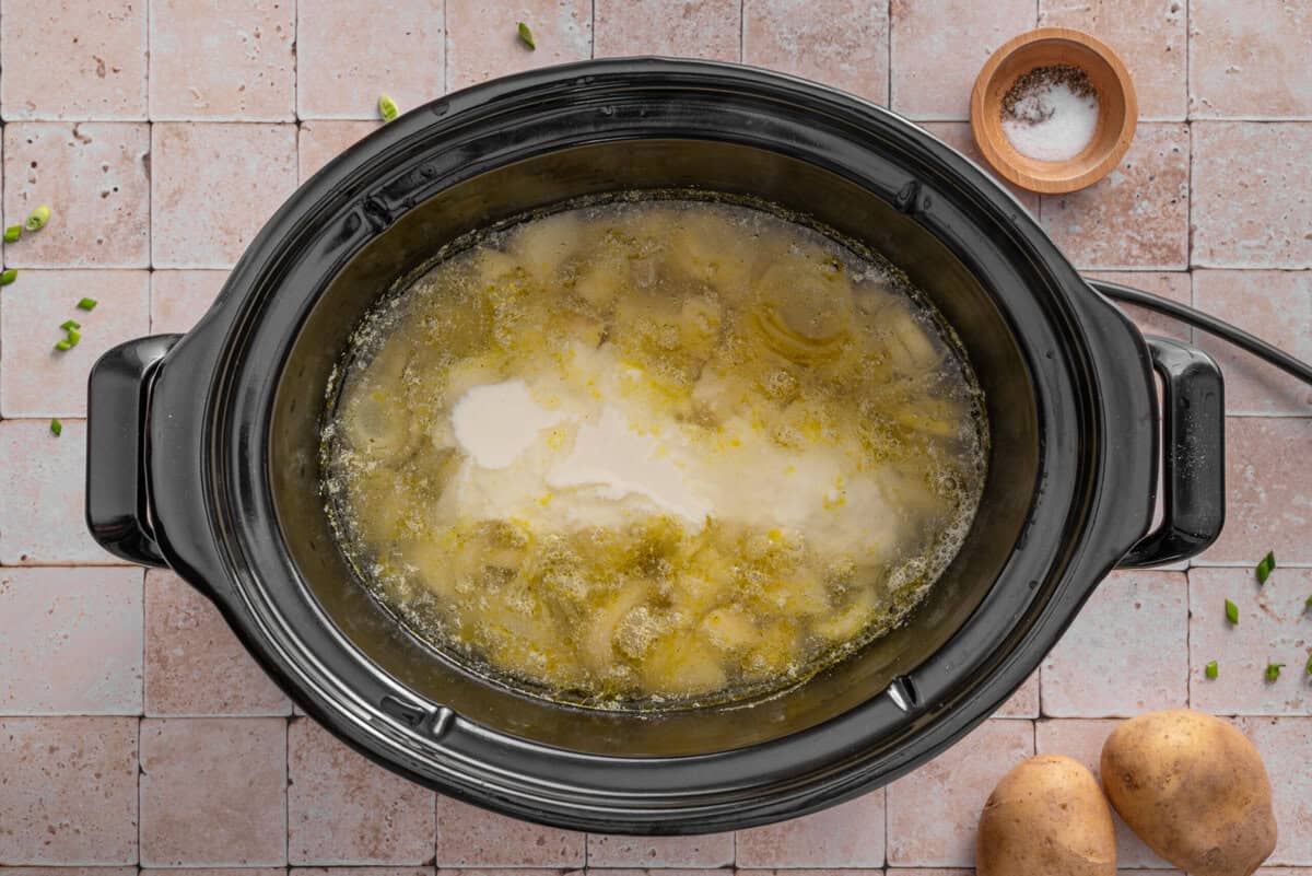 this shows me adding the creamy base I made into the slow cooker.