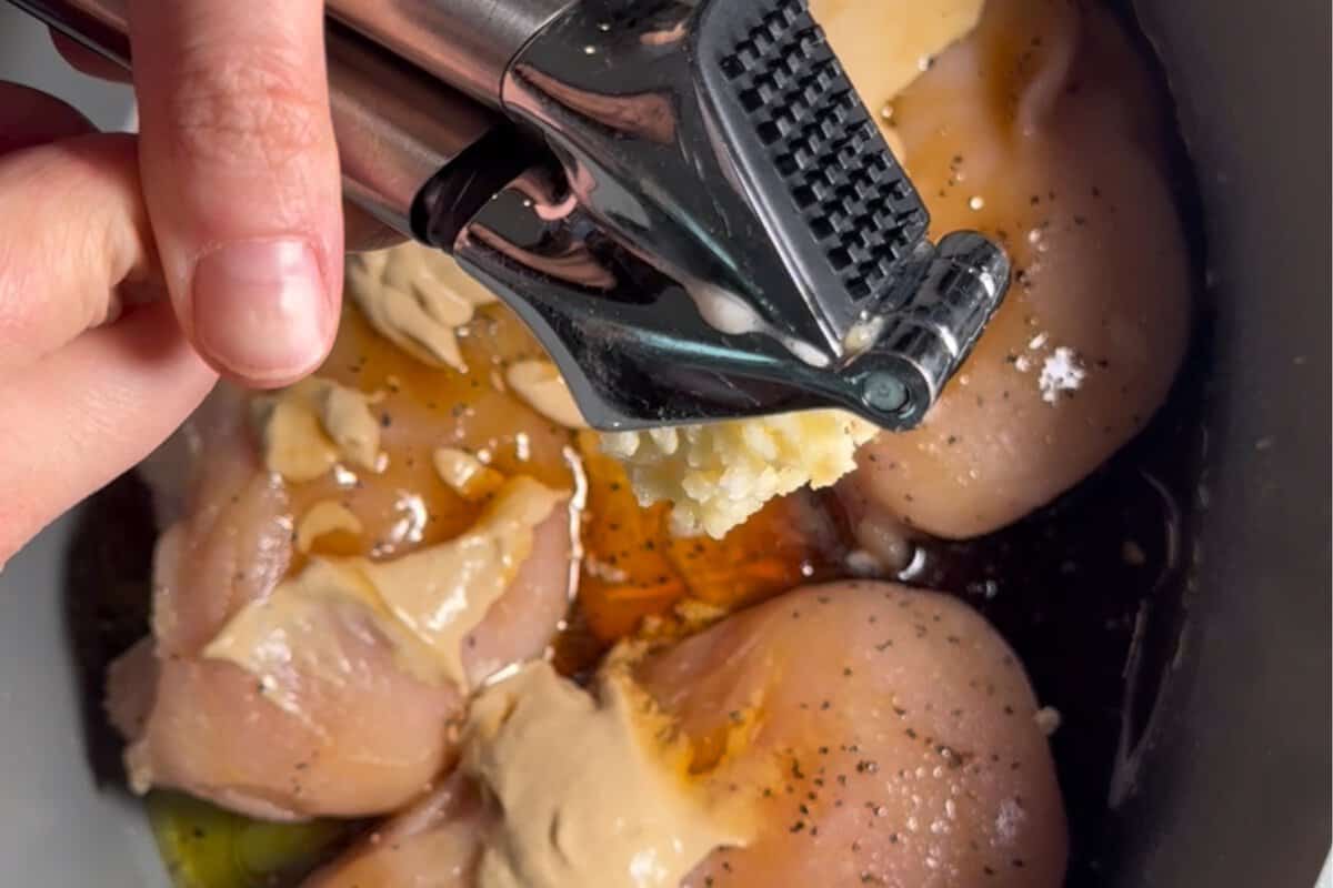 this shows me adding all the ingredients into the slow cooker from a top view 